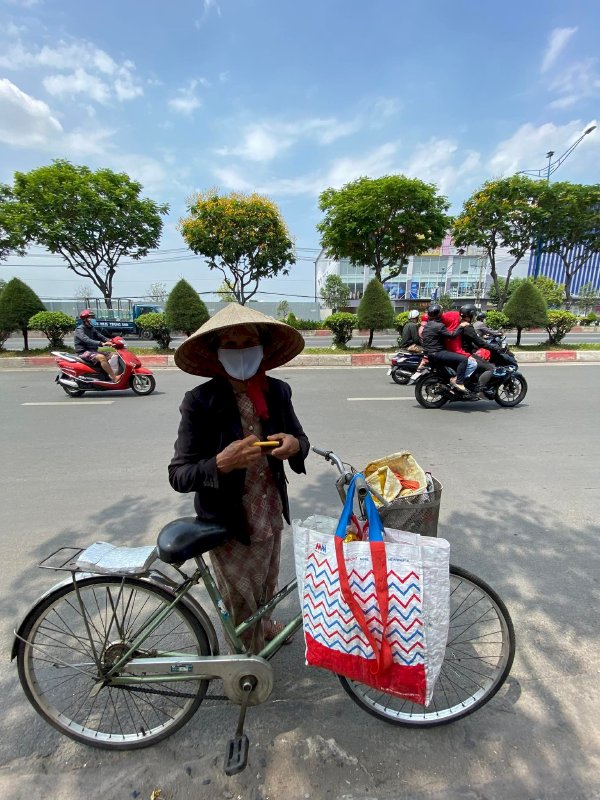 Hoa hậu Võ Thu Sương cúi xuống thật gần với người bán vé số, ve chai