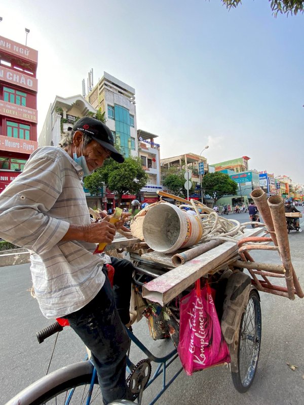 Hoa hậu Võ Thu Sương cúi xuống thật gần với người bán vé số, ve chai