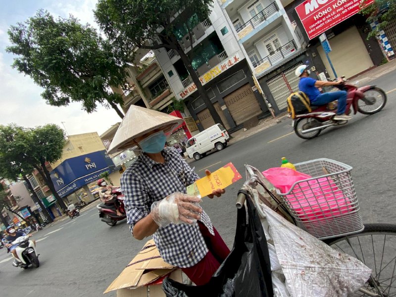 Hoa hậu Võ Thu Sương cúi xuống thật gần với người bán vé số, ve chai