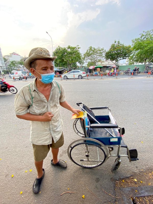 Hoa hậu Võ Thu Sương cúi xuống thật gần với người bán vé số, ve chai