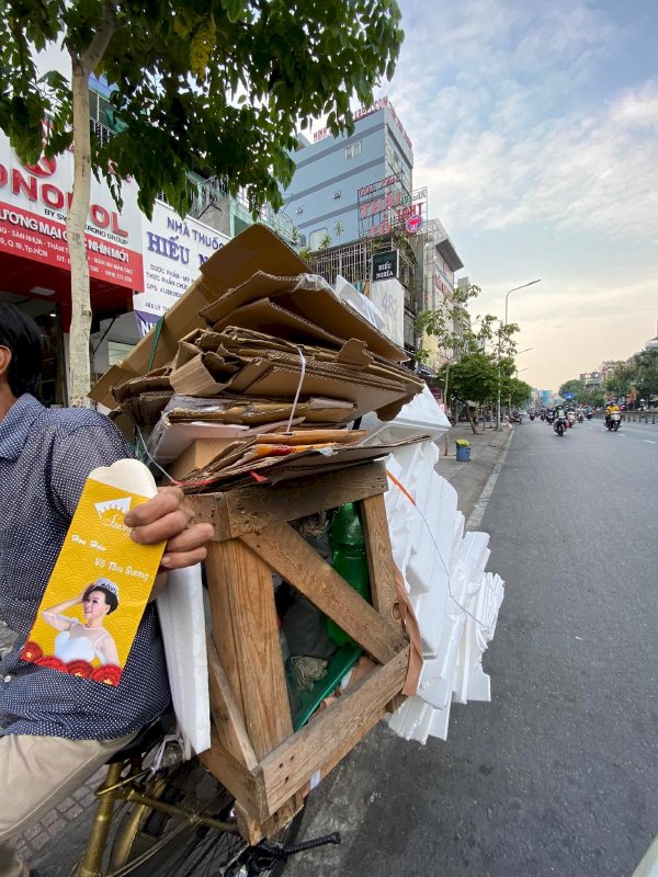 Hoa hậu Võ Thu Sương cúi xuống thật gần với người bán vé số, ve chai