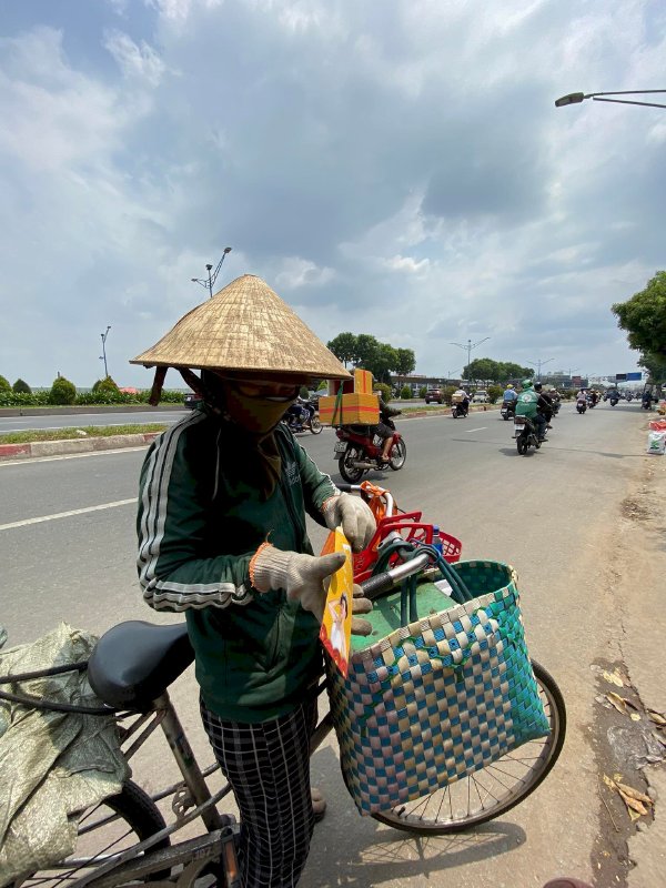 Hoa hậu Võ Thu Sương cúi xuống thật gần với người bán vé số, ve chai